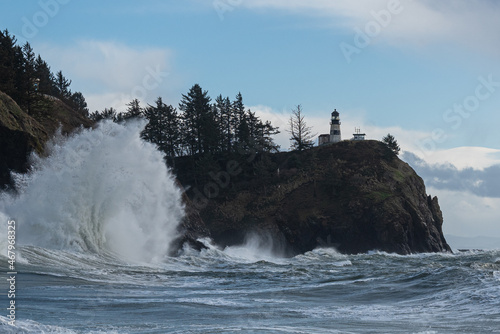 Large wave crashing under cliffs and light house on the Washington Coast, Pacific Northwest