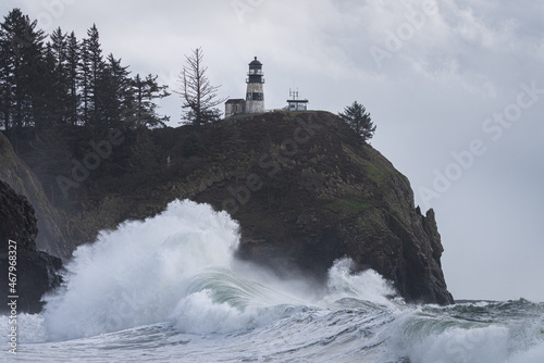 Powerful ocean waves crashing under light house during king tide storm on the Washington Coast