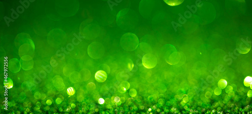 Green Christmas lights background, banner design. Shiny glowing surface with bokeh, abstract defocused glitter with sparkles