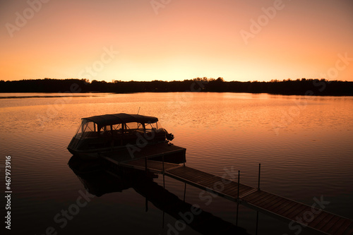 Pontoon boat mooring at sunset on the river in Laval