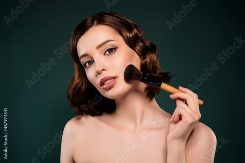 Photo of young stunning perfect gorgeous female apply foundation with big brush isolated on green color background