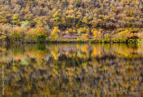 Autumn colorful background. Colorful trees with reflection in the water of Lake Ghirla, Valganna, province of Varese, Italy. photo