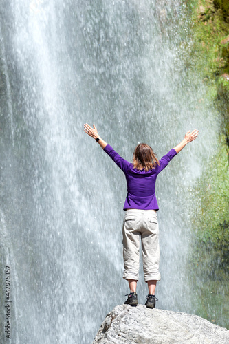 Happy girl watching a big waterfall