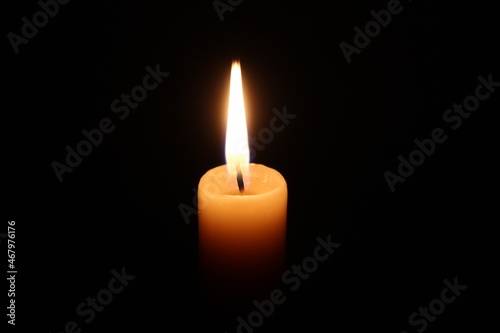 Flame of one candle on a horizontal black background top view in the middle