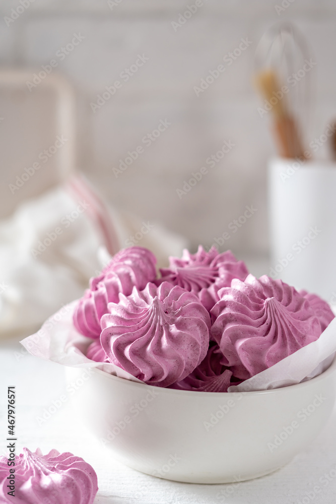 Italian and French meringue in a white plate on a light culinary background. Italian and French meringue in a white plate on a light culinary background.