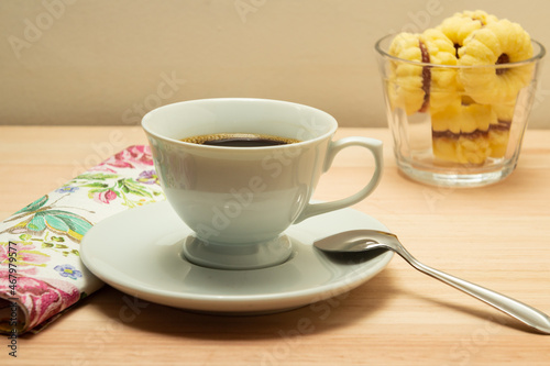 Uma xícara de café e uma porção de biscoitos amanteigados. photo