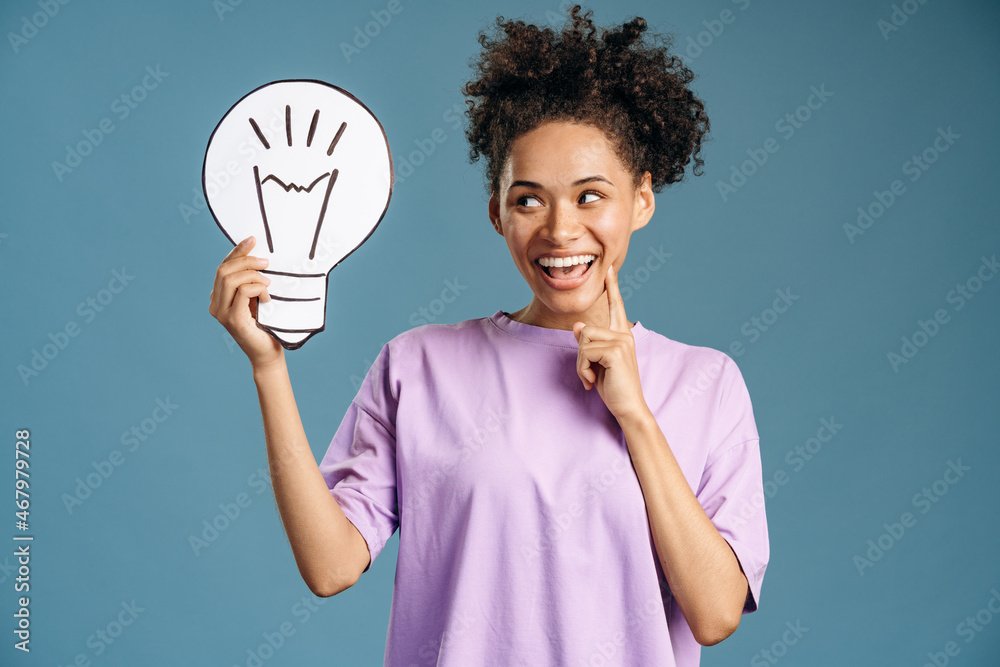 Woman pointing finger up and looking away with toothy smile Woman pointing finger up and looking away with toothy smile