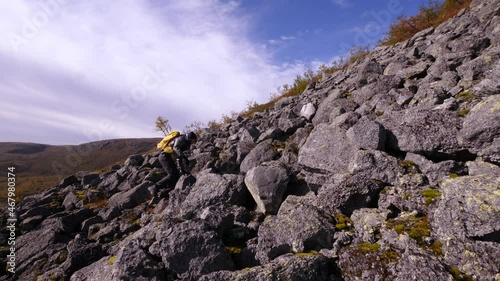Tourist traveler with a backpack in the mountains. Khibiny mountains in an autumn day. Nice view of the mountains. Snow-capped mountain peaks in the sun