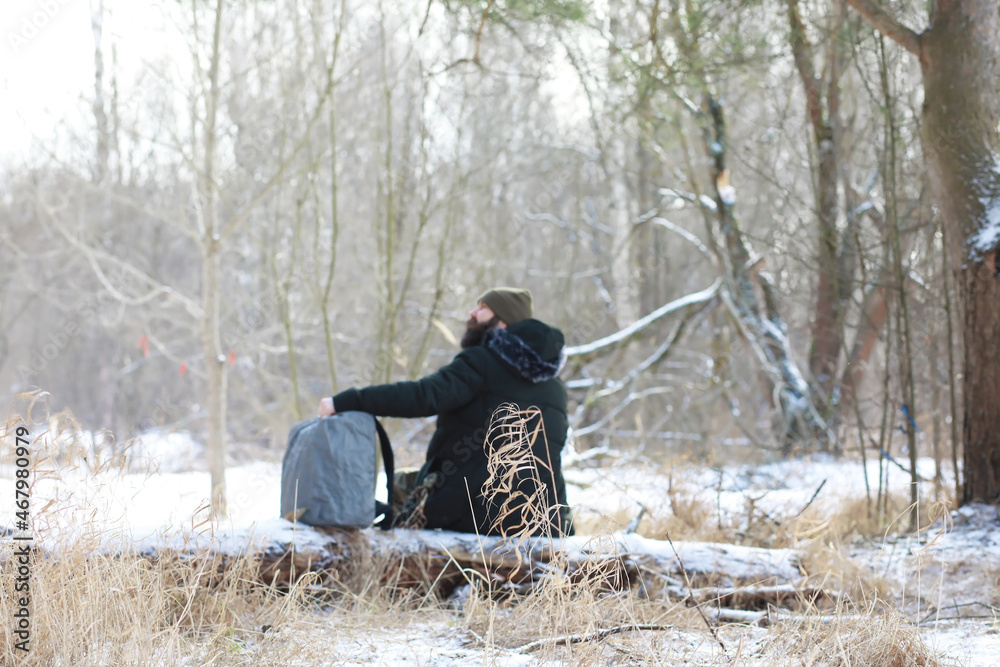 Outdoor portrait of handsome man in coat and scurf. Bearded man in the winter woods. Outdoor portrait of handsome man in coat and scurf. Bearded man in the winter woods.
