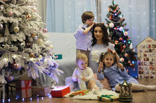 New Years Eve. The house is decorated for the holiday. Christmas tree with a garland and a family with gifts and a surprise.