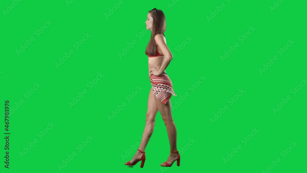 Side view of confident attitude bikini fashion model walking on catwalk. Full body isolated on green screen background Side view of confident attitude bikini fashion model walking on catwalk. Full body isolated on green screen background