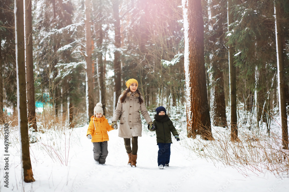 Happy family playing and laughing in winter outdoors in the snow. City park winter day.