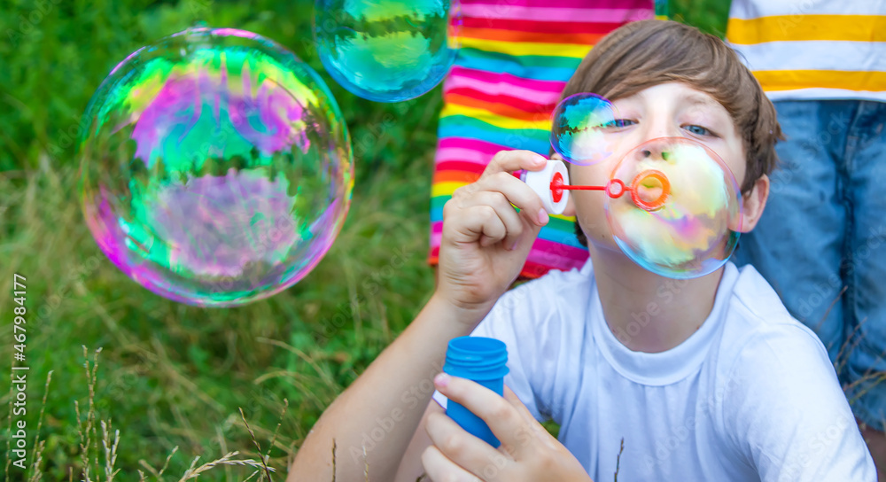 Children blow bubbles in the street. Selective focus. Children blow bubbles in the street. Selective focus.