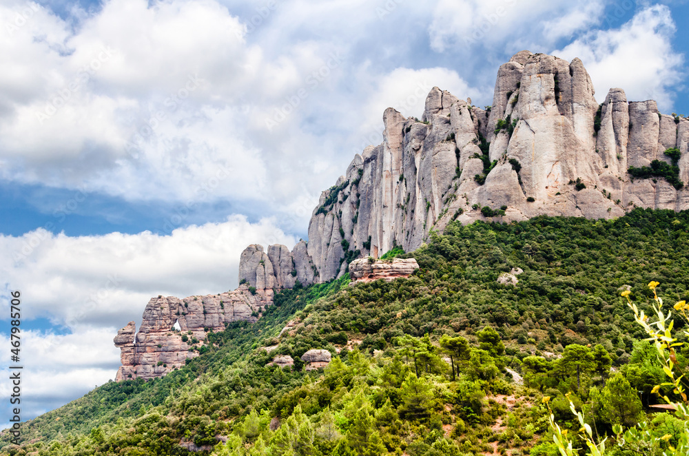 Views of the Montserrat massif or mountain province of Barcelona, Catalonia, on a day with white clouds and blue sky.