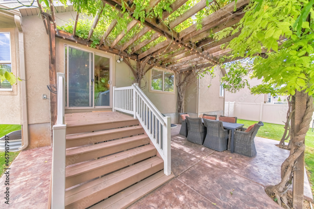 Outdoor patio with wooden pergola roof with vines and string lights