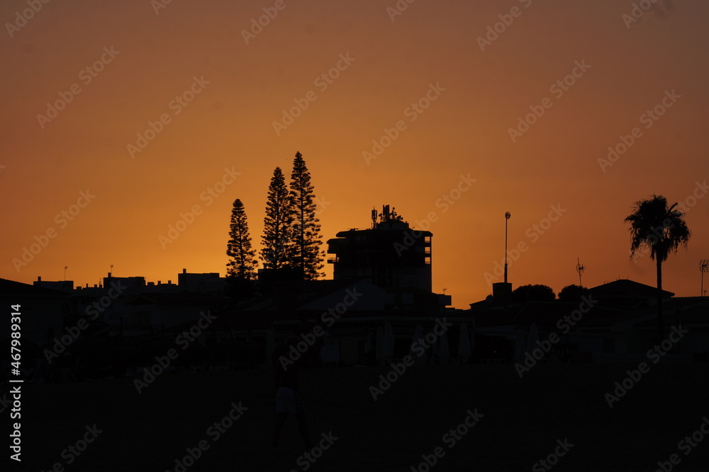 Photo of an orange sunset over some buildings