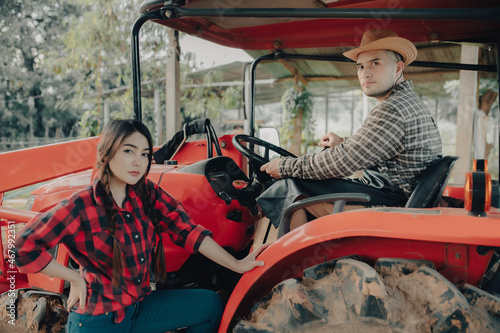 Asian couple working with tractor at cow farm