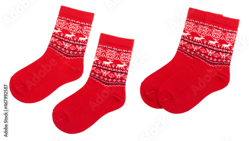 Pair of red nordic socks with deer and snowflake geometric ornament isolated on a white background