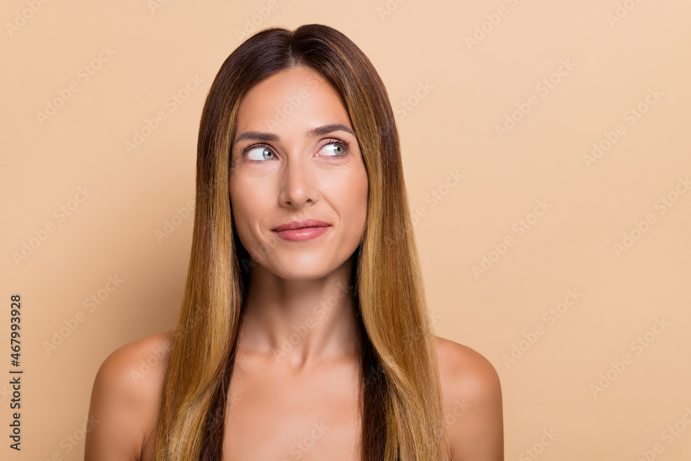 Fototapeta premium Portrait of attractive minded long-haired woman with fresh skin lifting effect thinking solution isolated over beige pastel color background