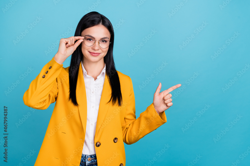 Photo of positive joyful attractive business lady smile point finger empty space isolated on blue color background Photo of positive joyful attractive business lady smile point finger empty space isolated on blue color background