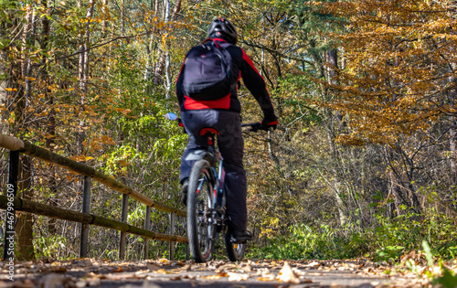A cyclist rides on way in an autumn landscape