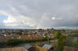 View of Cloudy Sky with Colourful Rainbow over Urban Area 