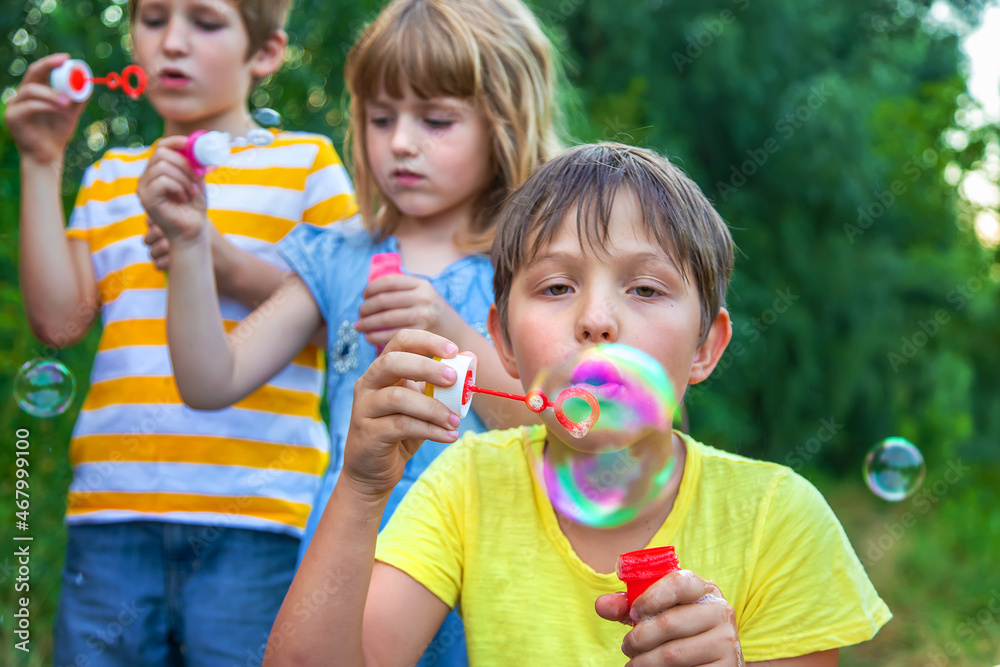 Children blow bubbles in the street. Selective focus. Children blow bubbles in the street. Selective focus.