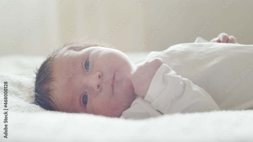 Close-up portrait of a young baby who has recently been born. Newborn infant boy at home. Window light. Close-up portrait of a young baby who has recently been born. Newborn infant boy at home. Window light.
