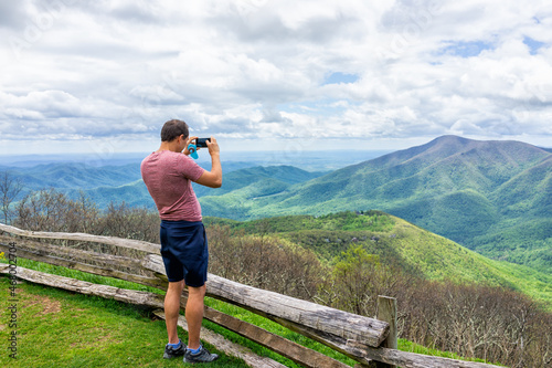Fotografiet Devil's Knob overlook with man standing photographing taking picture of mountain