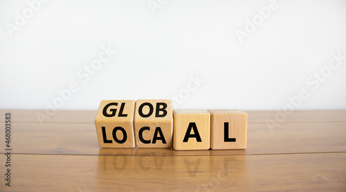Local or global symbol. Turned wooden cubes and changed the word 'local' to 'global'. Beautiful wooden table, white background. Business and local or global concept. Copy space. photo