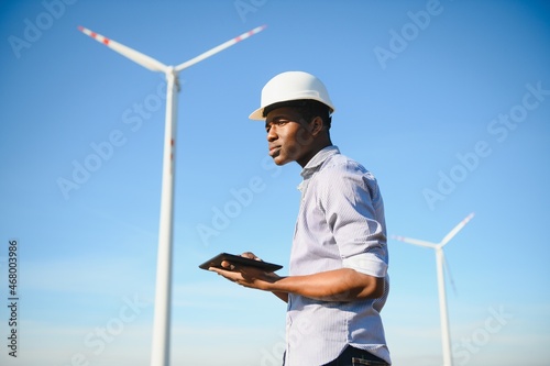 Engineer African man standing with wind turbine © Serhii