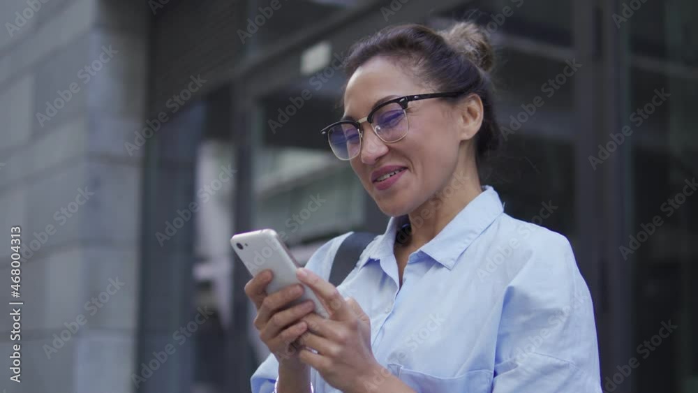 Happy business woman laughing with smartphone in hands, using entertainment app Happy business woman laughing with smartphone in hands, using entertainment app