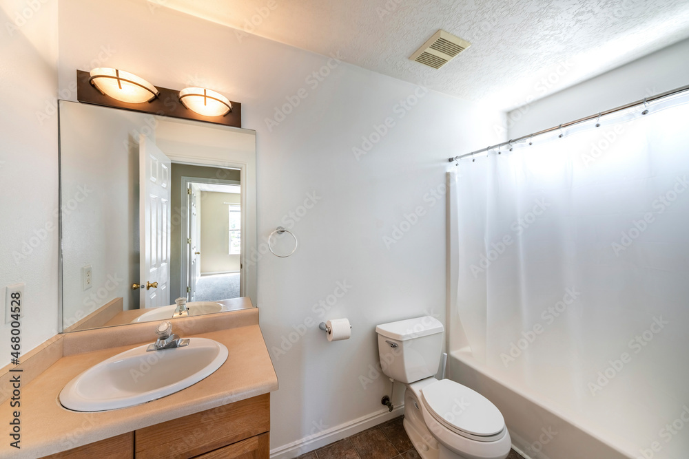 Small bathroom interior with white wall and brown vanity sink and countertop Small bathroom interior with white wall and brown vanity sink and countertop