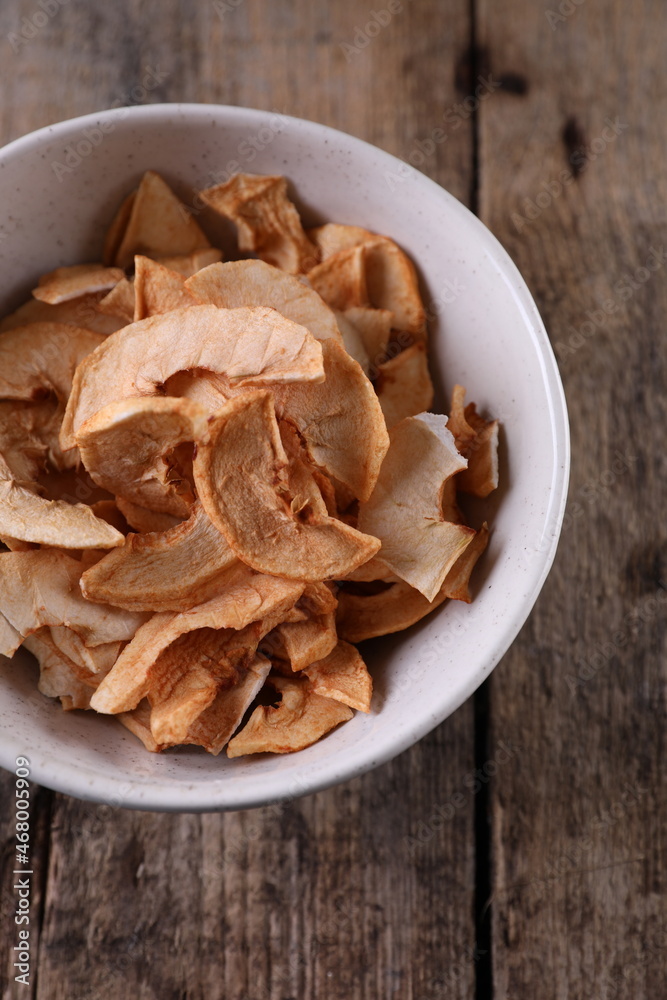 Dried apples in a bowl against a dark old wooden background Dried apples in a bowl against a dark old wooden background