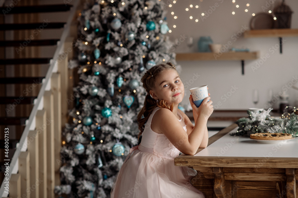 Portrait of a cute girl dreaming about gifts under the Christmas tree. Concept for family celebrating new year and christmas at home during coronavirus pandemic