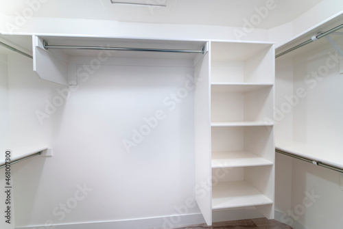 White built-in shelving units inside a walk-in closet