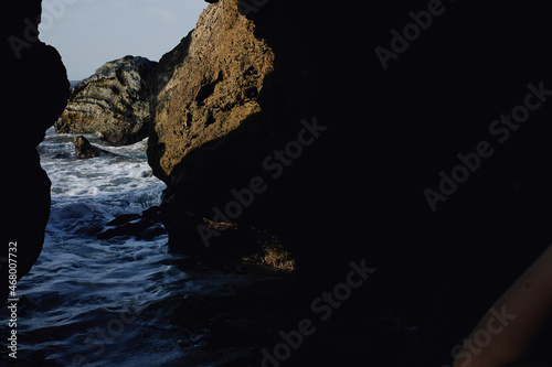 woman in black swimsuit sunglasses summer rocks exotic