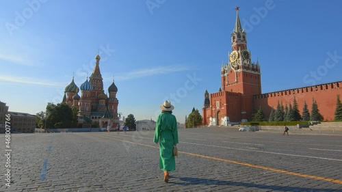 An attractive girl in a green dress walking to St. Basil's Cathedral
