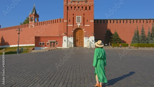 A beautiful girl in a green dress at the gates of the Spasskaya Tower