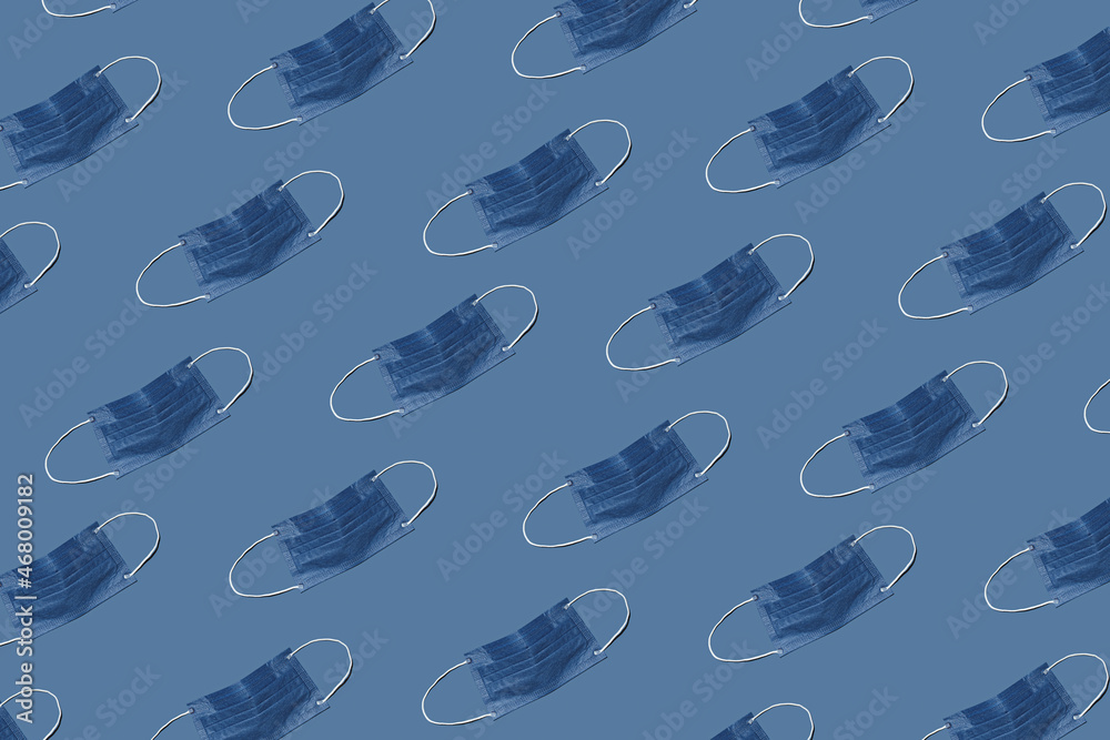Pattern made with Coronavirus or COVID-19 prevention medical surgical face masks for protection. Pandemic or epidemic pattern concept. Flat lay. Pastel blue background. Pattern made with Coronavirus or COVID-19 prevention medical surgical face masks for protection. Pandemic or epidemic pattern concept. Flat lay. Pastel blue background.