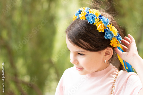 Little beautiful smiling girl in Ukrainian national wreath decoration