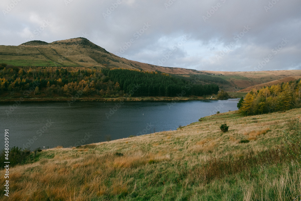 Breathtaking forest view on a mountain slope and a lake - autumnal landscape.