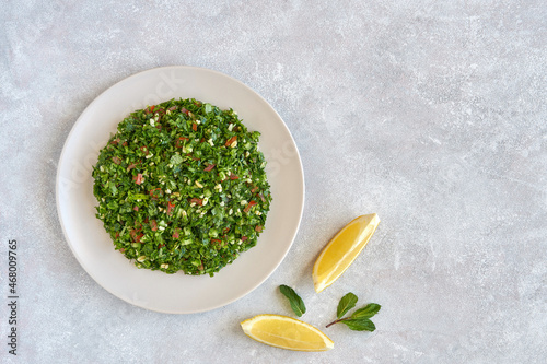 Tabbouleh salad with parsley and bulgur. Top view with copy space photo