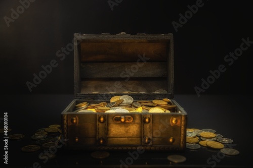 Heap of coins in small wooden chest