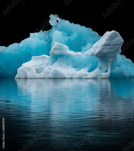 Iceberg reflected in calm water from a glacier in southeast Alaska. 