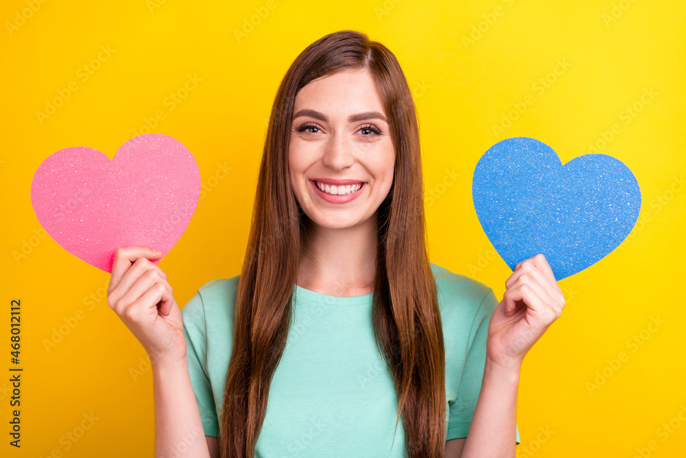 Photo of funky brunette hairdo young lady hold hearts wear teal t-shirt isolated on yellow color background Photo of funky brunette hairdo young lady hold hearts wear teal t-shirt isolated on yellow color background