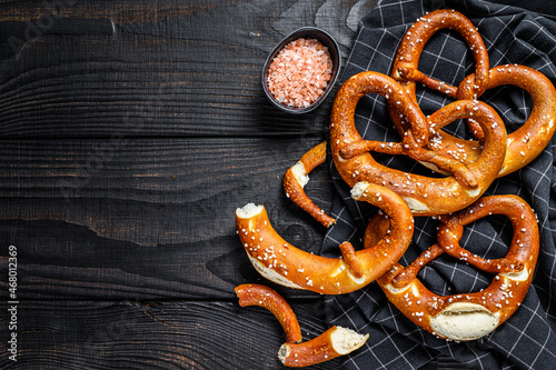 German baked Salted pretzels on a wooden rustic table. Black wooden background. Top view. Copy space
