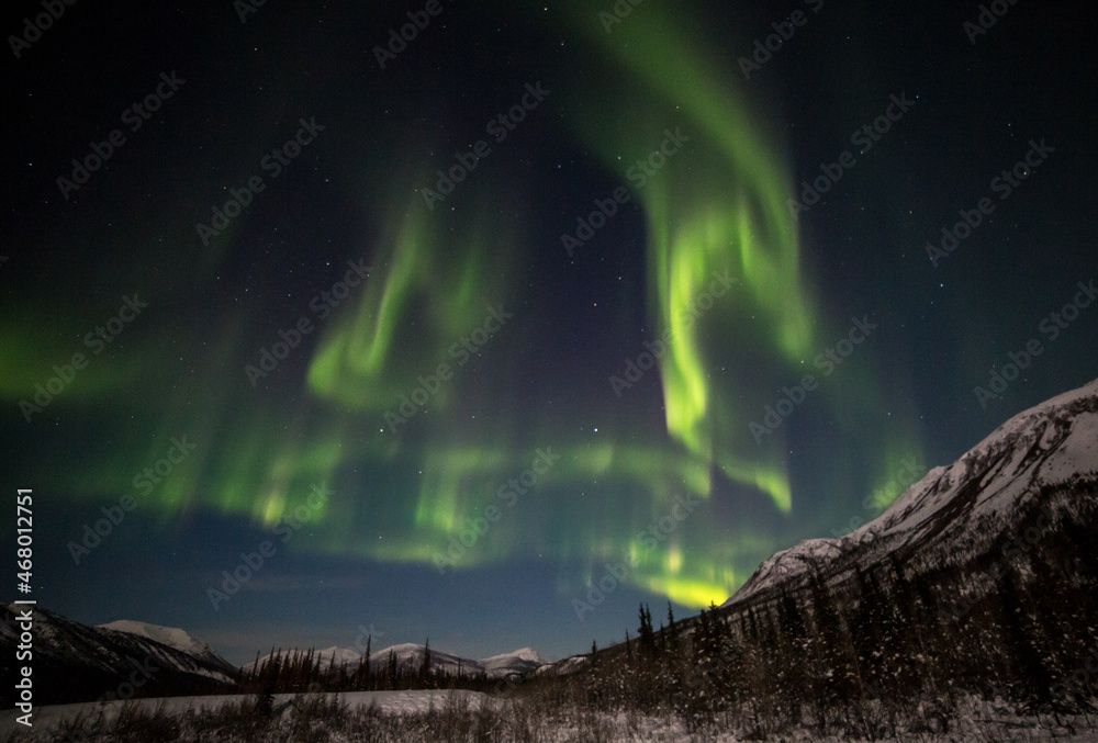 The aurora borealis or northern lights dance over the mountains of the Brooks Range in northern Alaska. 