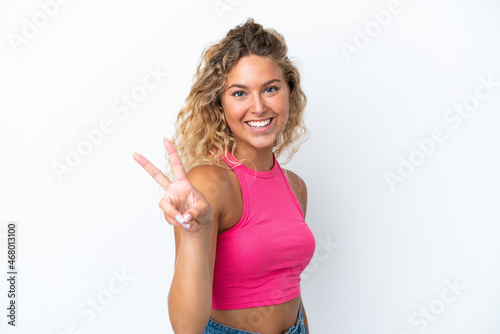 Girl with curly hair isolated on white background smiling and showing victory sign