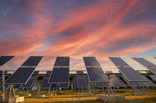 Solar panels against sundown sky